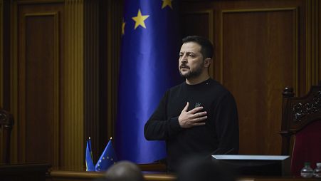 In this photo provided by the Press Service Of The President Of Ukraine on Nov. 19, 2024, Ukraine's President Zelenskyy listens to the national anthem before his speech