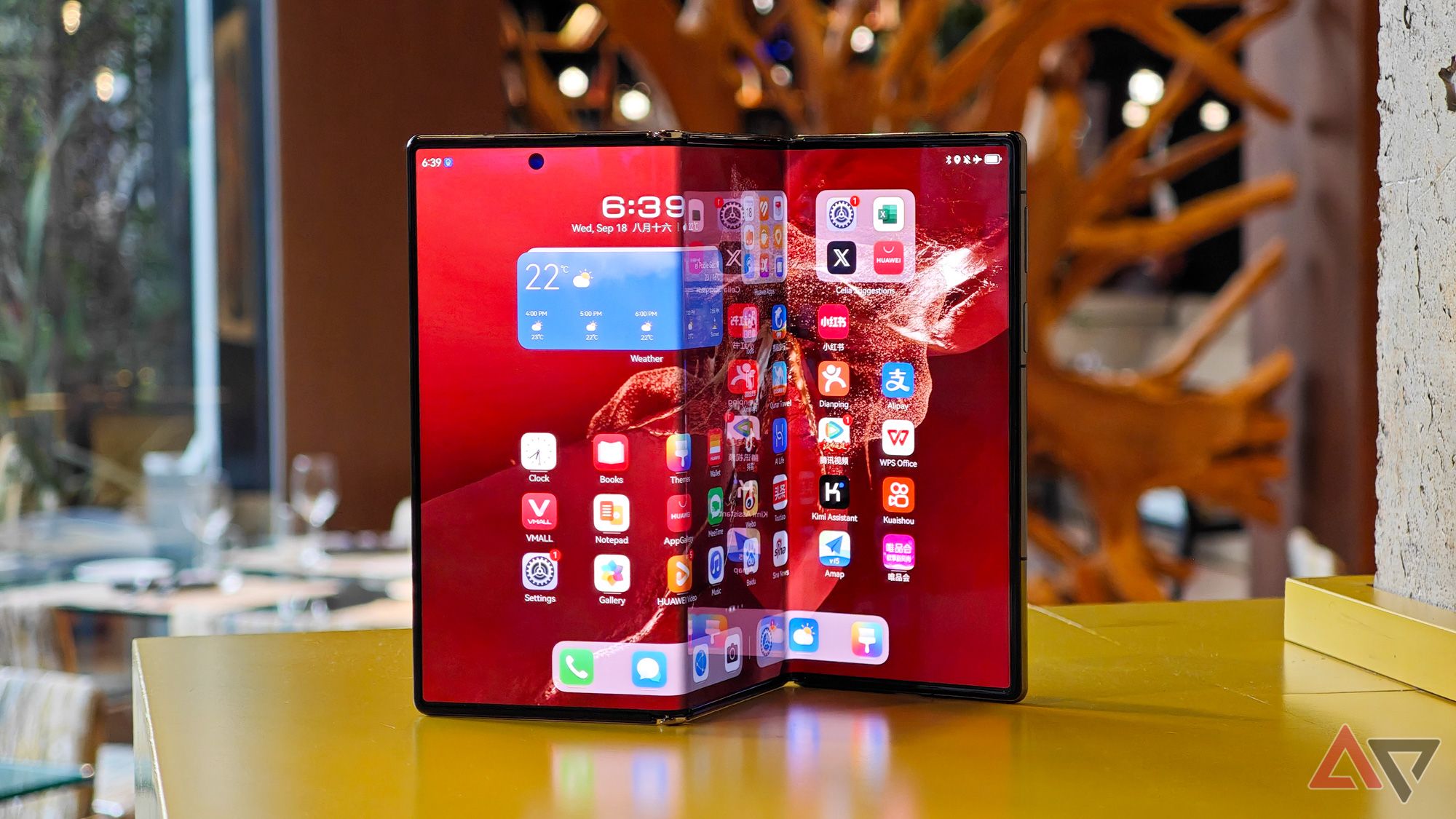 The Huawei Mate XT standing on a table in the unfolded position