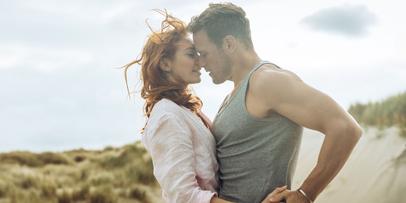 Eleanor Tomlinson and Sam Heughan dancing on the beach