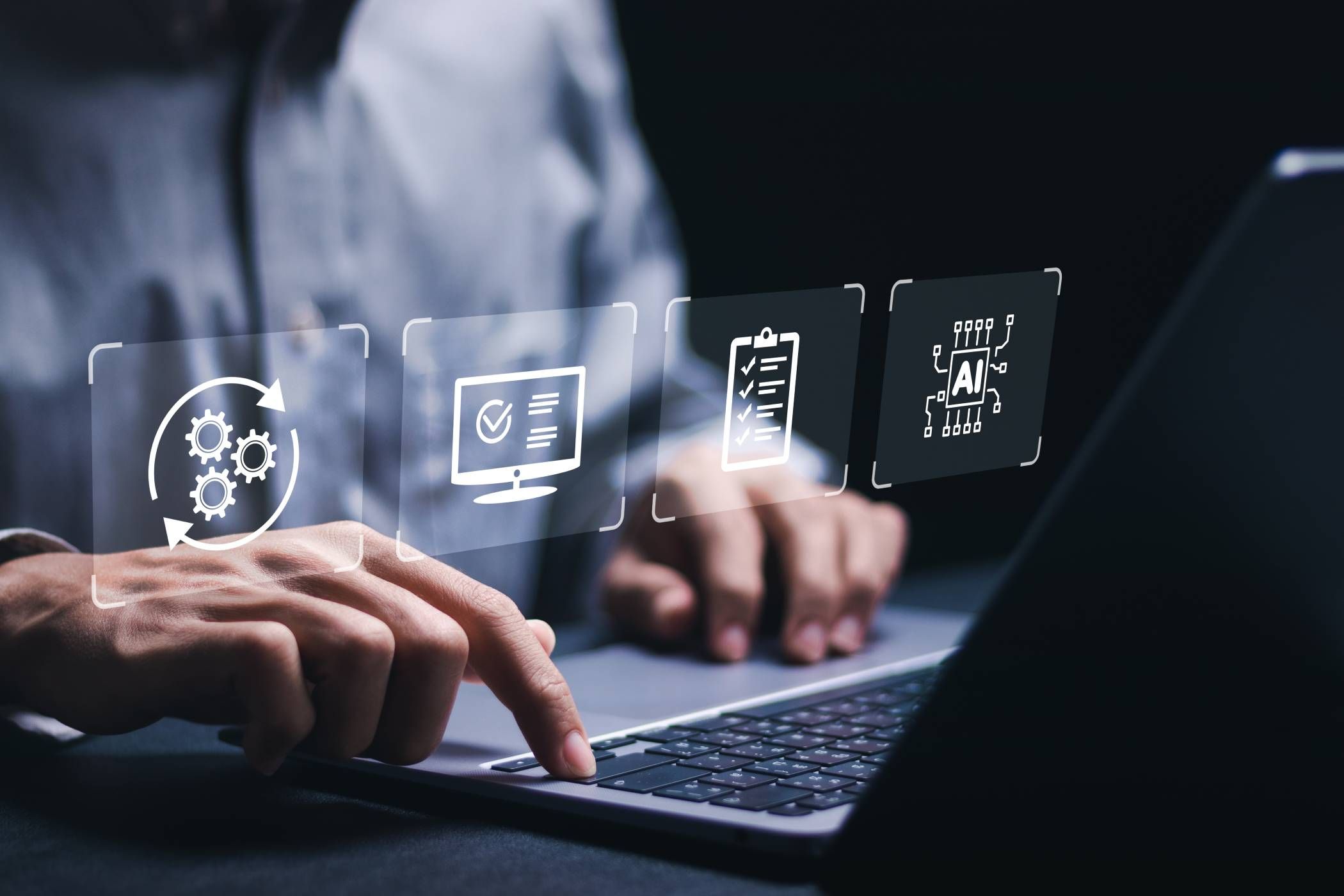 Businessman working on laptop with automation symbols hovering above his hands (1)