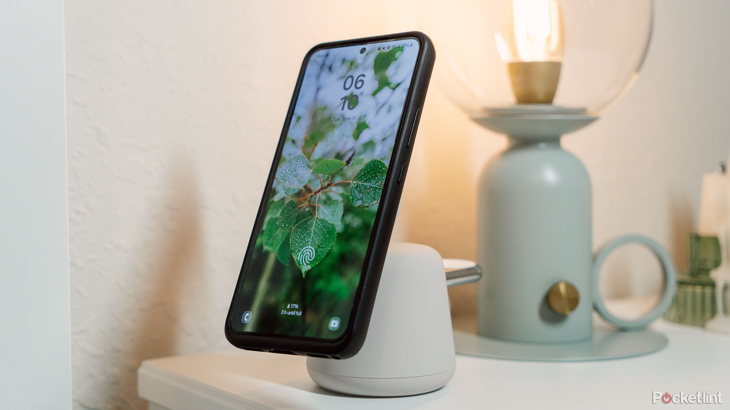 A nightstand with the Belkin Boost Charge Pro wireless charger and a Galaxy phone on it. 