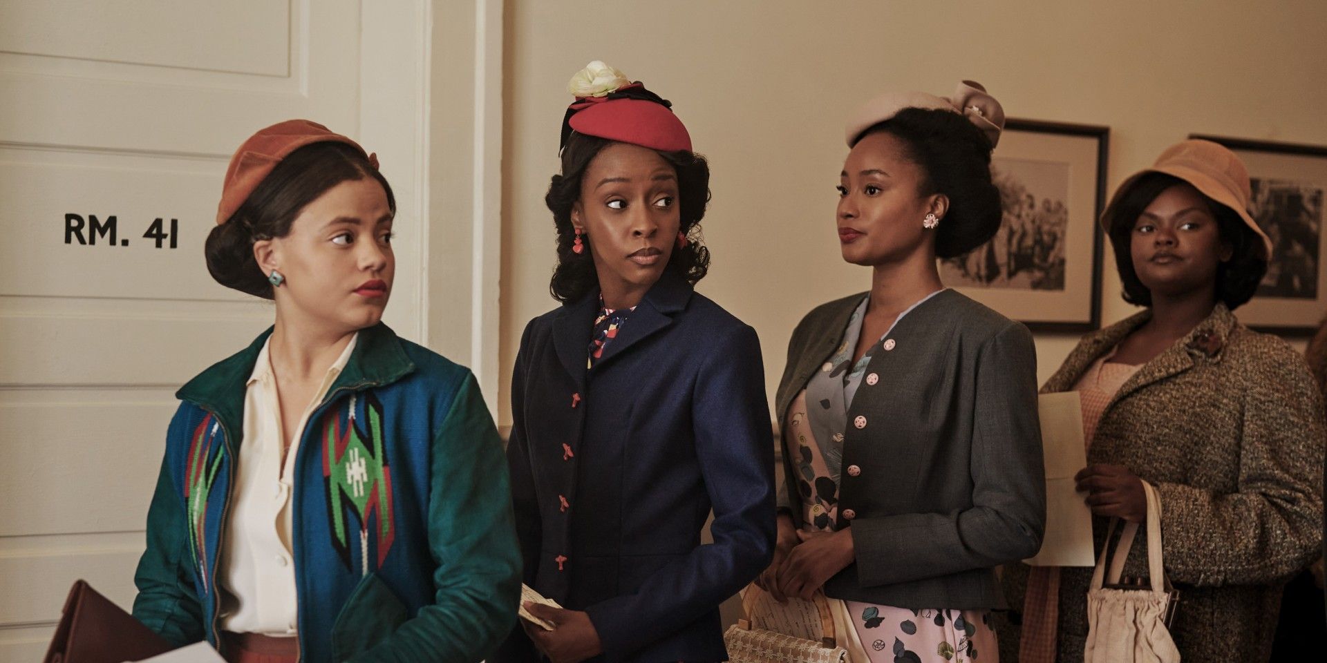 four women in period clothing stand in a line in an office in The Six Triple Eight