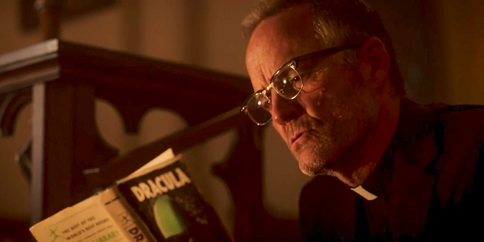 Father Callahan (John Benjamin Hickey) reading the Dracula book in Salem's Lot (2024)