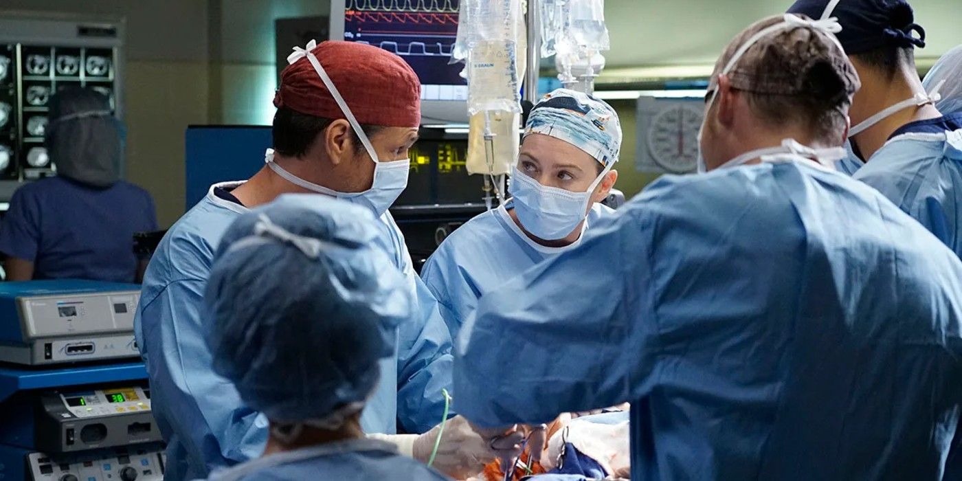 Meredith looks intently at another doctor while in full surgical dress in the middle of a surgery in Grey's Anatomy