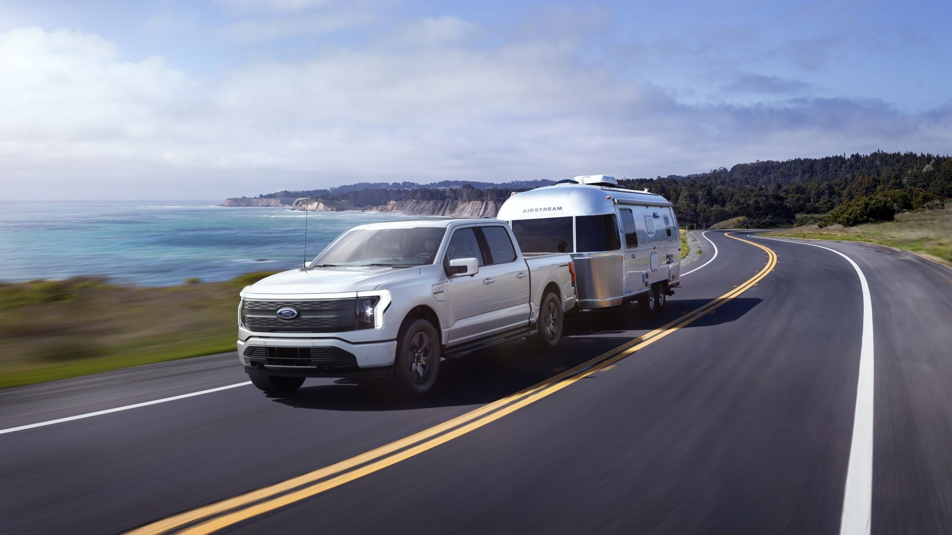 Ford F-150 Lightning towing silver airstream camper