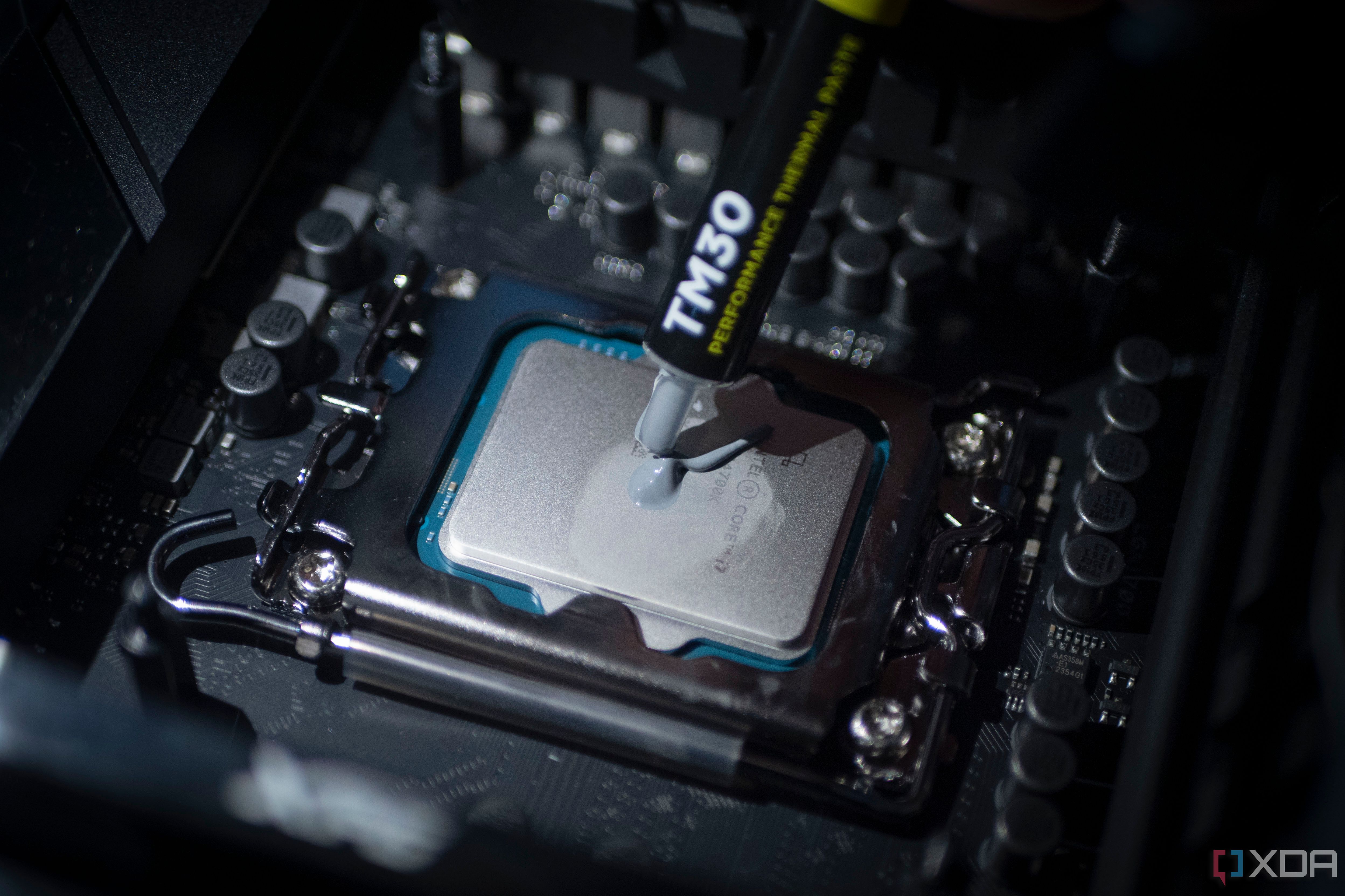 An image showing thermal paste being applied on an Intel Core i7-14700K CPU.