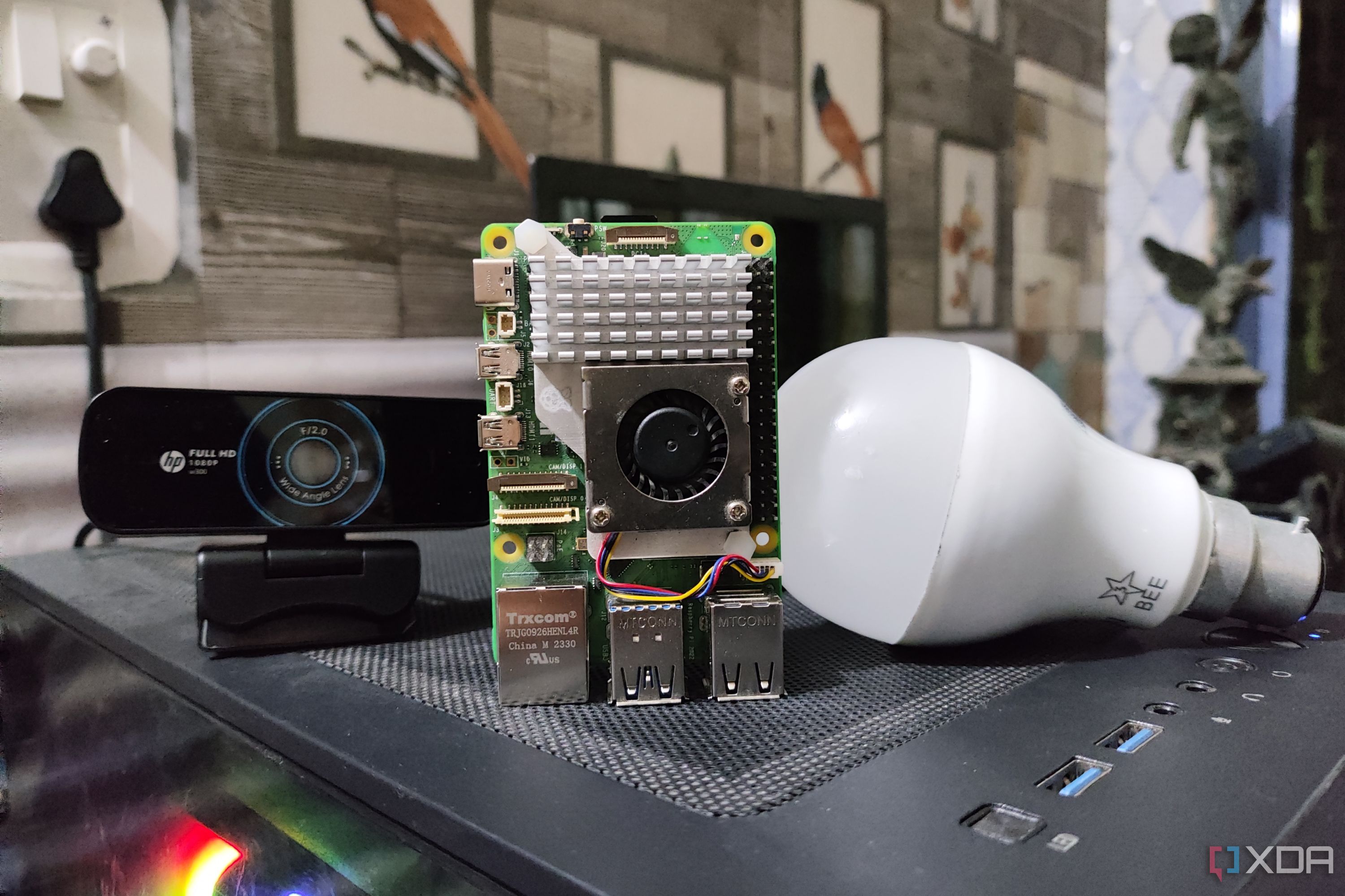 A Raspberry Pi 5 placed next to a webcam and a bulb