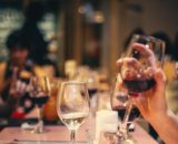 Persone che assaggiano calici di vino - © Pexels