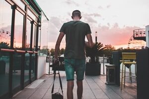 man holding black sling bag while walking