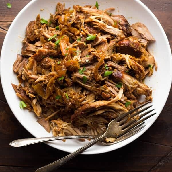 slow cooker maple pulled pork in white bowl with forks