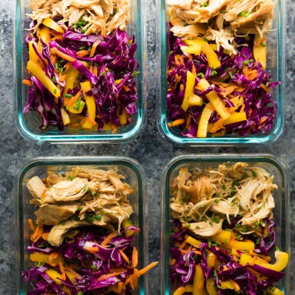 overhead shot of four glass containers filled with chipotle honey chicken taco salad bowls