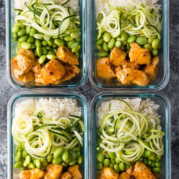 overhead shot of four firecracker chicken meal prep bowls