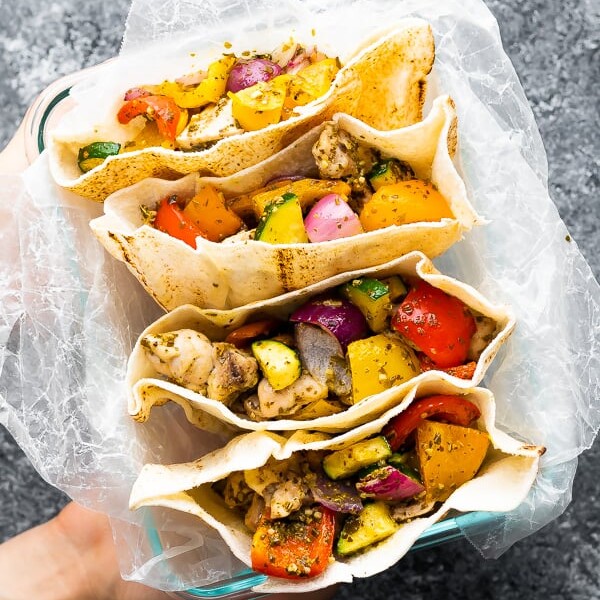 overhead shot of four pesto chicken pitas on parchment paper