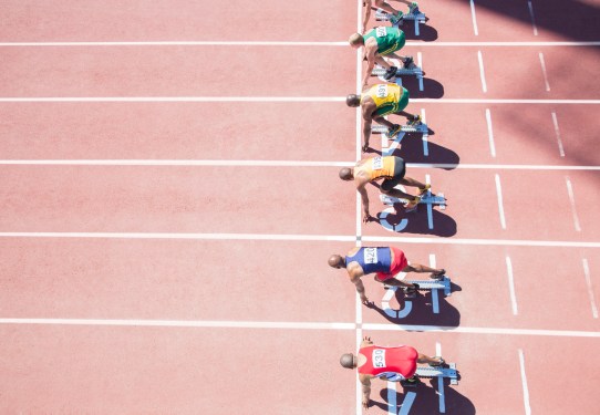 overhead view of runners waiting at starting block on track