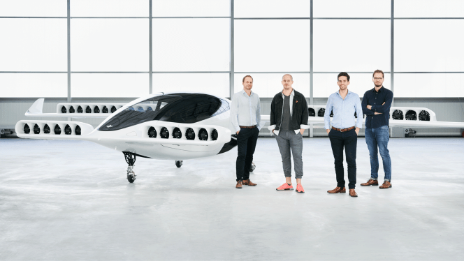 people standing in front of Lilium 5 seater parked in hangar