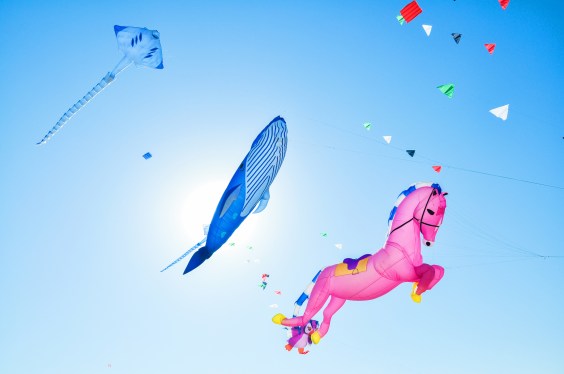 Low Angle View Of Kites Flying Against Clear Blue Sky