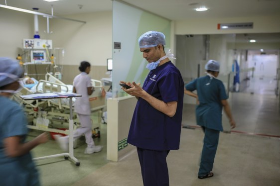 A doctor looks at his mobile phone in an intensive care unit.