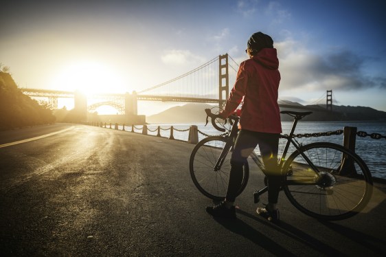 Commuter with road racing bicycle and Golden Gate Bridge