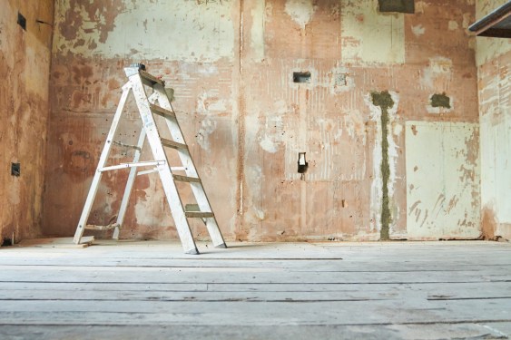 A step ladder standing in an empty domestic room mid renovation.