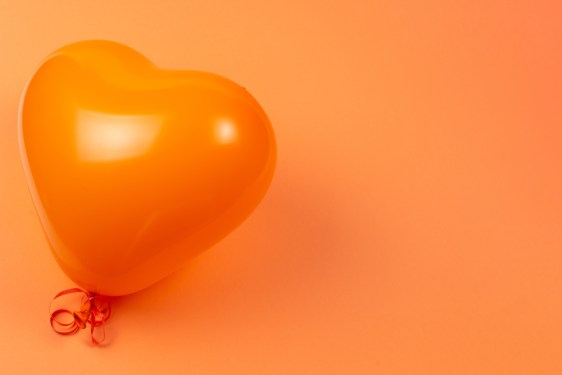 Image of an orange heart balloon on an orange background.