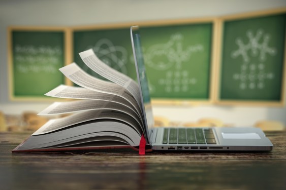 Open laptop and book on a desk, edtech