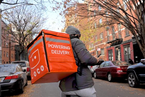 delivery rider on joco e-bike in nyc with food case that says "powering delivery"