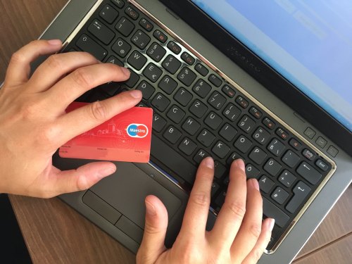 hands on laptop keyboard, credit card at the ready