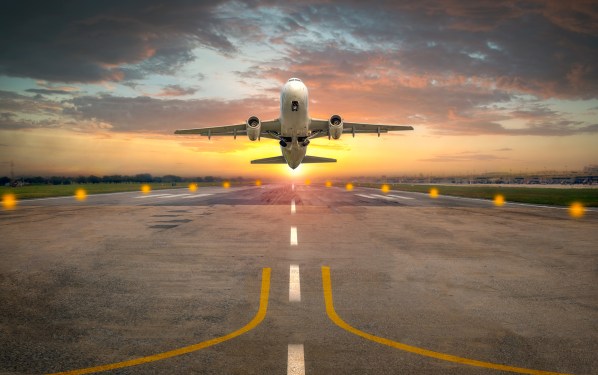 Airplane taking off from the airport runway in beautiful sunset light