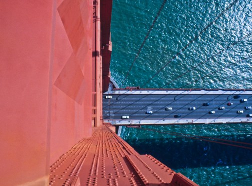 An aerial view of the road deck of the Golden Gate Bridge shot from the top of a tower,