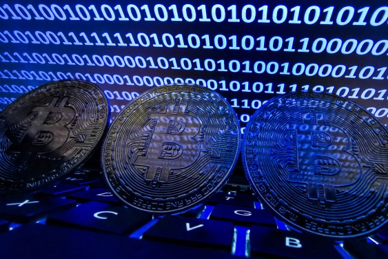 Bitcoin is seen with binary code displayed on a laptop screen in an illustration photo.