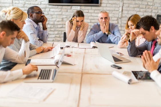 Image of people at an office meeting not having a good time.