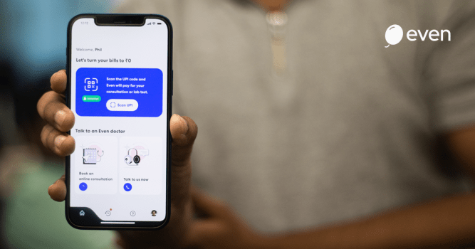 Man holding smartphone displaying Even Healthcare app.