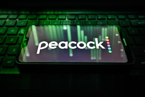 Peacock logo on a phone sitting on a keyboard