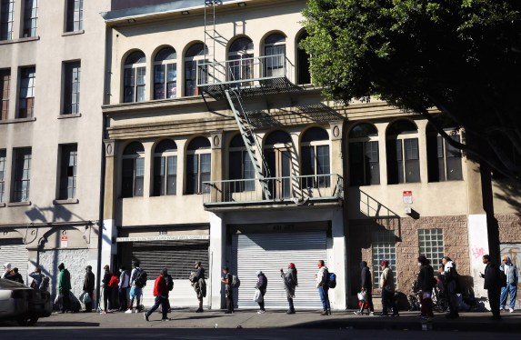 a photo of a line of people queuing up for housing assistance in Los Angeles