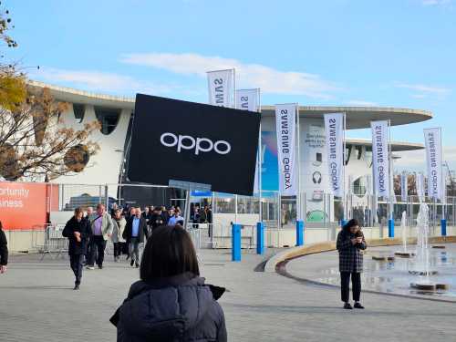 A woman holds an Oppo sign outside the Fira Gran Via during MWC 2023.