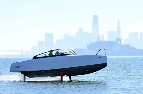 Alcatraz island and the San Francisco skyline are seen in the horizon as French sailor Tanguy de Lamotte, CEO of Candela US, drives the company's "flying" electric C-8 boat in San Francisco bay, California on February 8, 2023. - What appears at a glance to be a simple pleasure hydrofoil rises above the water as it picks up speed in San Francisco Bay, grabbing the attention of ferry passengers. But this hydrofoil is different. For one thing, it makes very little noise because it is electric. "It's half plane and half boat; almost like riding a magic carpet," French sailor Tanguy de Lamotte said from the helm of the 8.5-meter (28-foot) long C8. (Photo by JOSH EDELSON / AFP) (Photo by JOSH EDELSON/AFP via Getty Images)