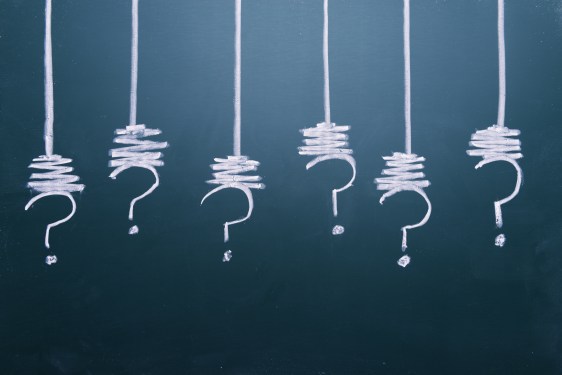 Image of question marks drawn on a chalkboard.