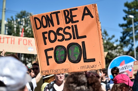 Sign at protest reads "don't be a fossil fool."