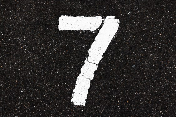 A white number seven painted on black ashphalt