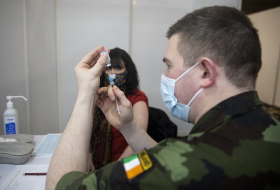 a patient at a GP practice in Mountmellick, prepares to receive her second dose of the Moderna vaccine from an Army officer with the Irish Defence Forces, at the GP vaccination clinic in the Midlands Park Hotel, Portlaoise