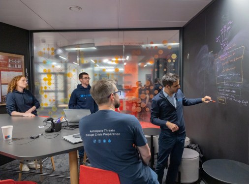 colleagues standing around blackboard