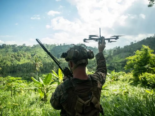 A U.S. Marine Corps small unmanned aerial system operator assigned to Weapons Company, Battalion Landing Team 1/5, 15th Marine Expeditionary Unit, launches an X2D Skydio drone.