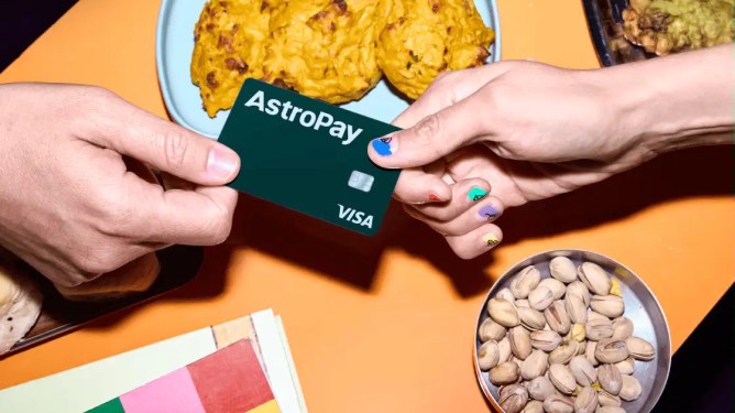 AstroPay card held by two people