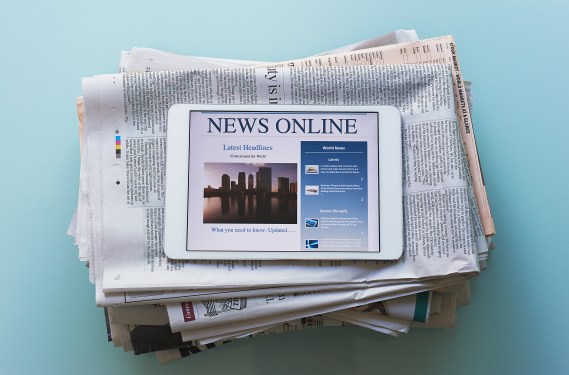 Tablet computer on stack of newspapers