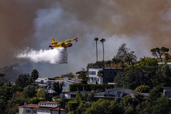 Pacific Palisades, CA - January 07: A Super Scooper plane drops water on the Palisades fire on Tuesday, Jan. 7, 2025 in Pacific Palisades, CA. (Brian van der Brug / Los Angeles Times via Getty Images)