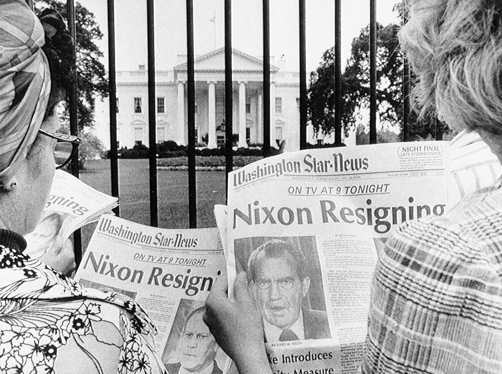 Tourists read newspapers in front of the White House following President Richard Nixon's resignation. (Photo via Getty Images)