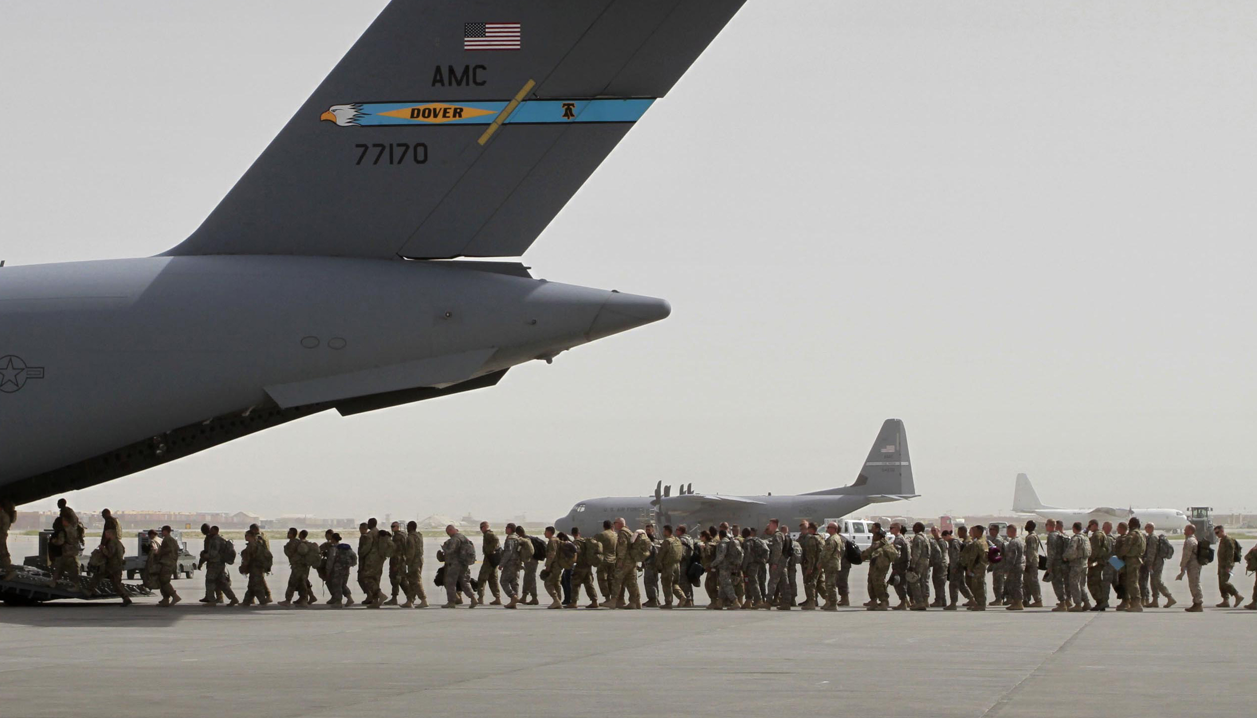 FILE- In this Thursday, July 14, 2011 file photo, U.S. soldiers board a U.S. military aircraft as they leave Afghanistan, at the U.S. base in Bagram, north of Kabul, Afghanistan. U.S. A bill passed by Congress allowing the families of 9/11 victims to sue the Saudi government has reinforced to some in the Arab world a long-held view that the U.S. only demands justice for its own victims of terrorism, despite decades of controversial U.S. interventions around the world. (AP Photo/Musadeq Sadeq, File)