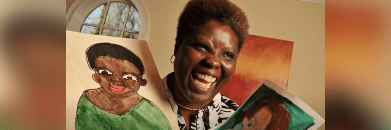 Disability advocate and Black woman Lois Curtis holding two paintings and smiling