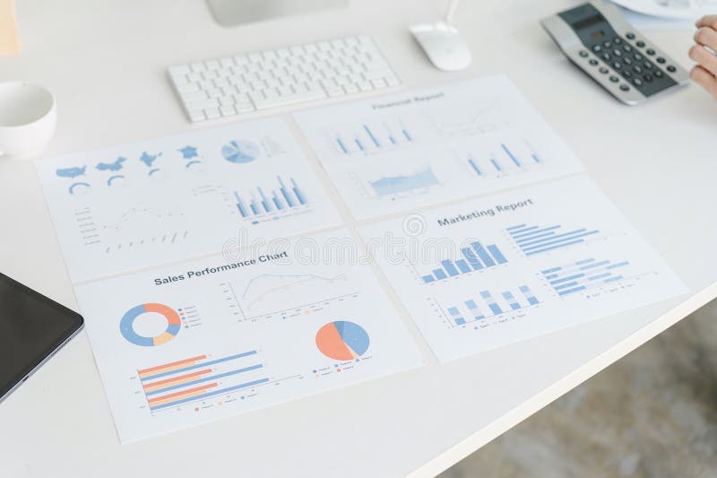 An array of business reports and marketing analysis charts are spread out on a desk, depicting various data stock image