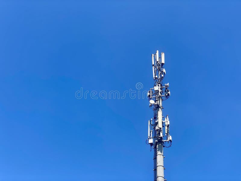 Cell tower, blue sky background. 3g, 4g, 5g. Mobile communications, various data transmission systems are installed on stock photo